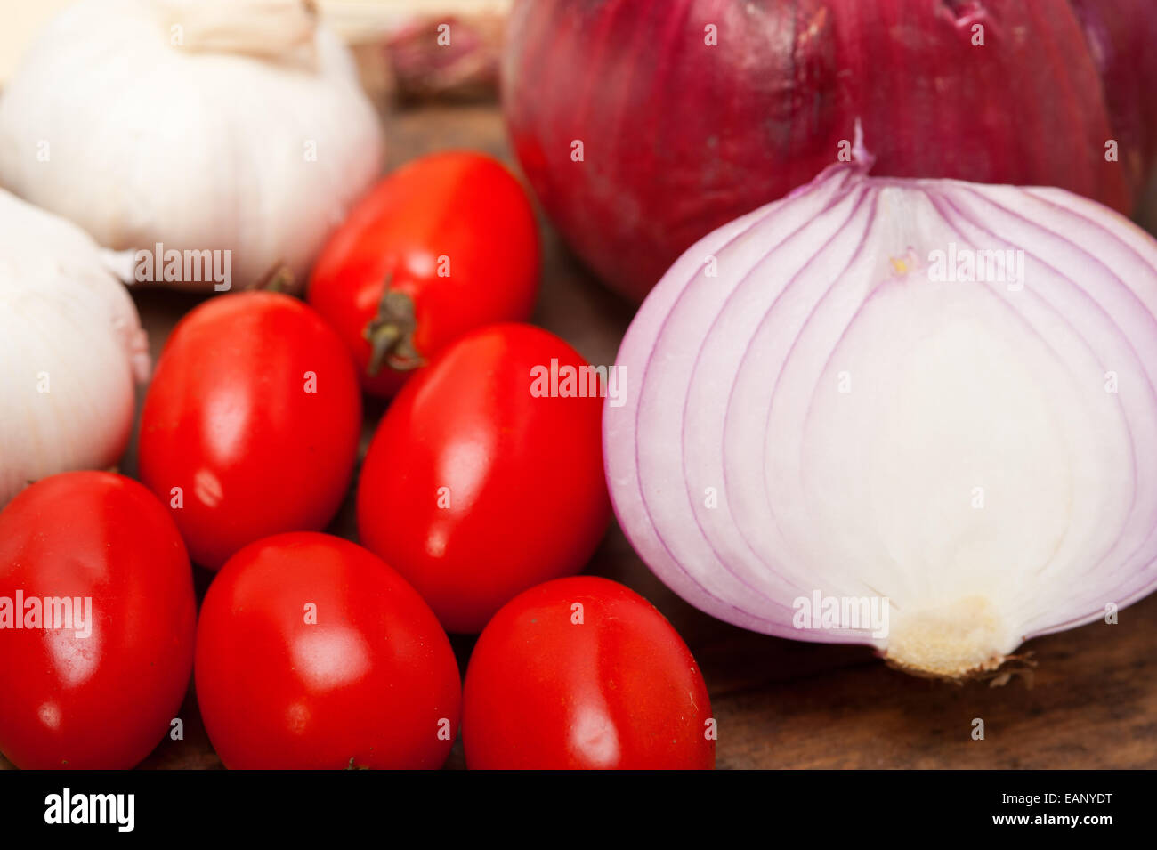 Zwiebel Knoblauch und Tomaten Grundlagen der italienischen Küche auf rustikalen Tisch Stockfoto