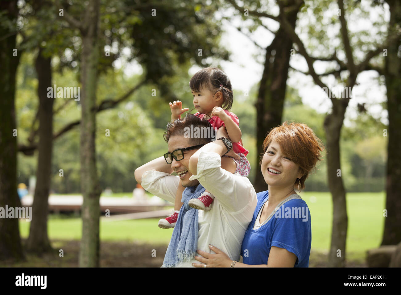 Familie in einem Park. Zwei Eltern und ein Kleinkind. Stockfoto