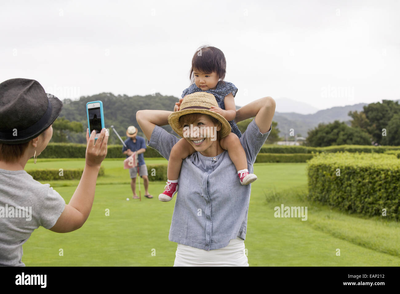 Familie auf einem Golfplatz. Ein Kind auf eine Frau Schultern. Stockfoto