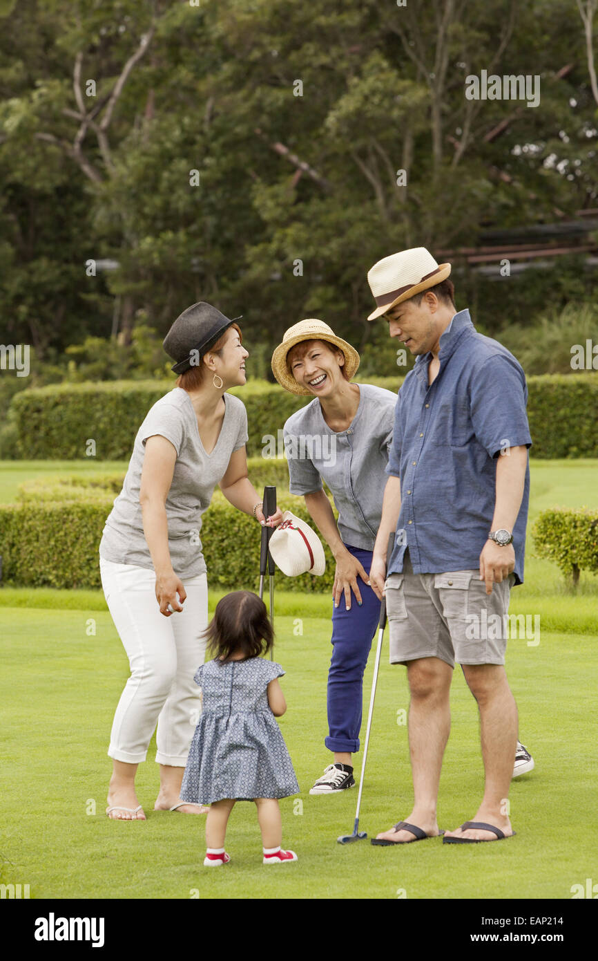 Familie auf einem Golfplatz. Ein Kind und drei Erwachsene. Stockfoto