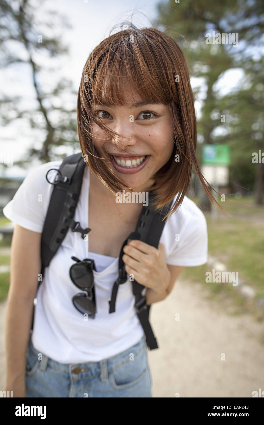 Junge Frau im Park tragen einen Rucksack. Stockfoto