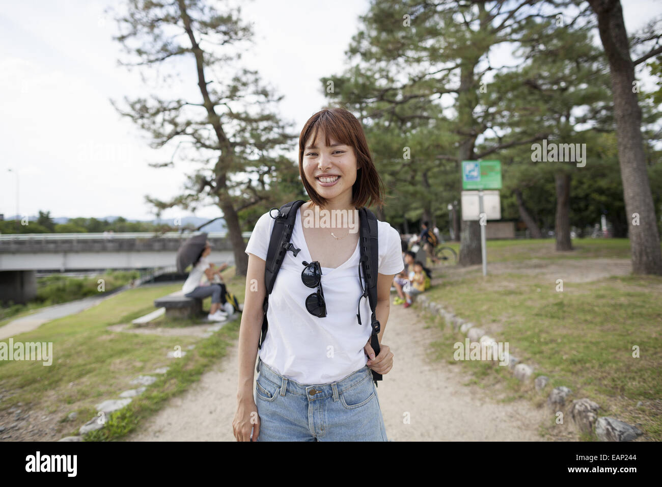 Junge Frau im Park tragen einen Rucksack. Stockfoto