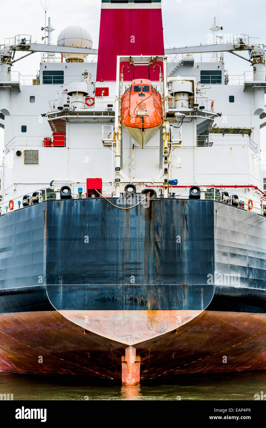 Heck eines Containerschiffs mit orange Rettungsinsel Stockfoto