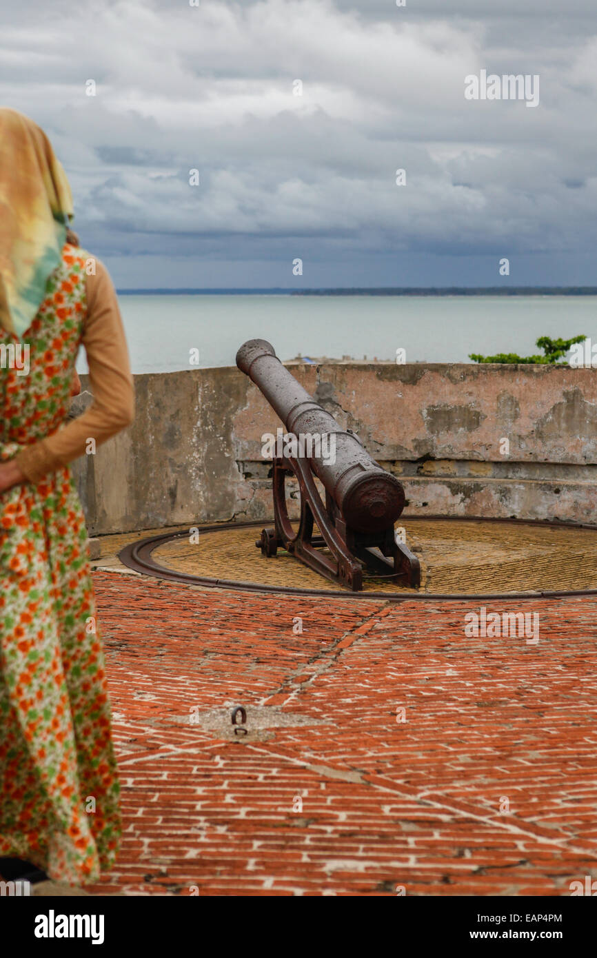 Eine lokale Frau untersucht eine Kanone im Fort Marlborough, ein 18. englische Jahrhundert Fort befindet sich in Bengkulu Stadt, Sumatra. Stockfoto