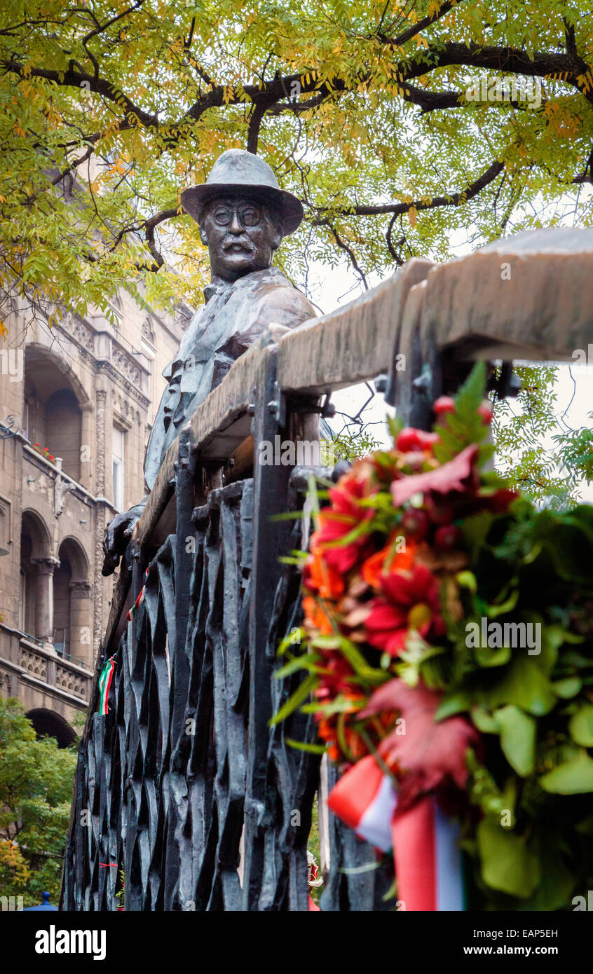 Budapest Ungarn, steht eine Statue von Imar Nagy auf einer Brücke blickte auf Blüten, die an der Gedenkstätte geblieben sind. Stockfoto