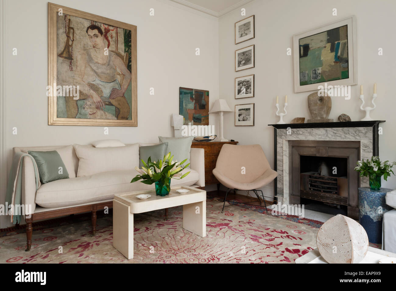 Ein Alexander Garbell Gemälde an der Wand im Wohnzimmer mit gemusterten Teppich und eleganten Sofa. Das Gemälde über dem Kamin ist Stockfoto