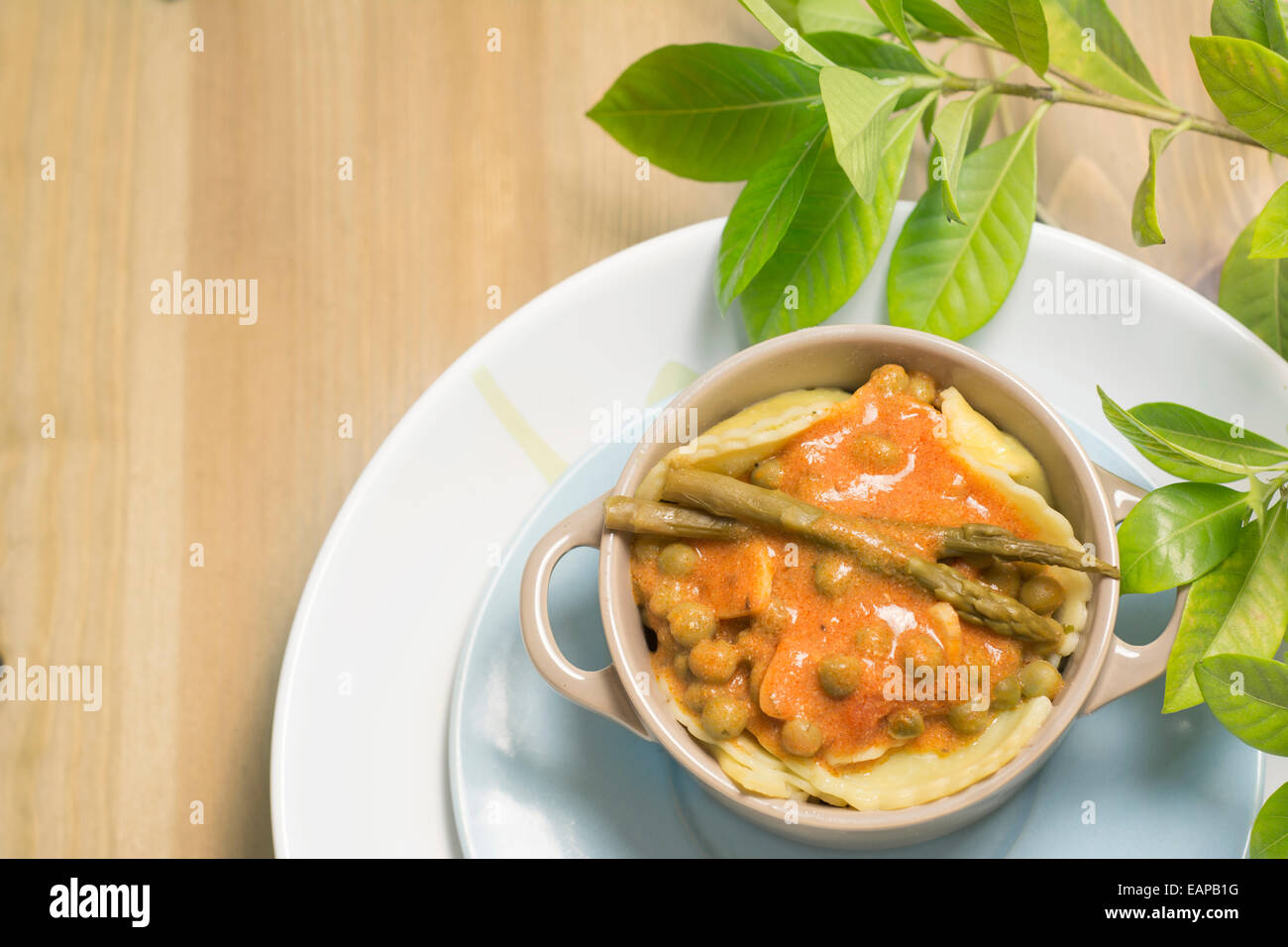 Kasserolle, italienische Pasta mit Tomaten Spargel und Erbsen auf hölzernen Hintergrund gefüllt Stockfoto