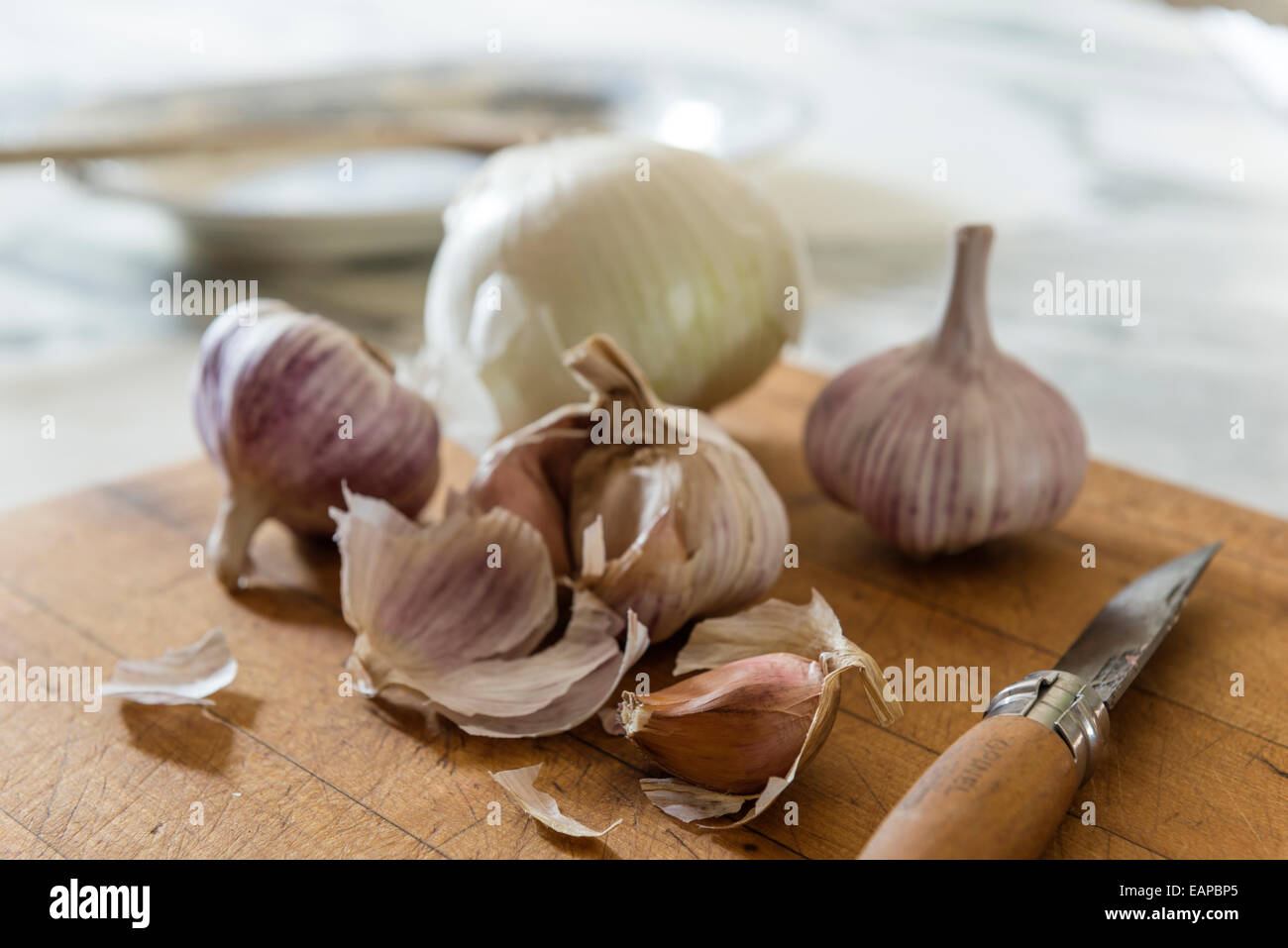 Opinel Taschenmesser auf Schneidebrett mit Knoblauch Stockfoto