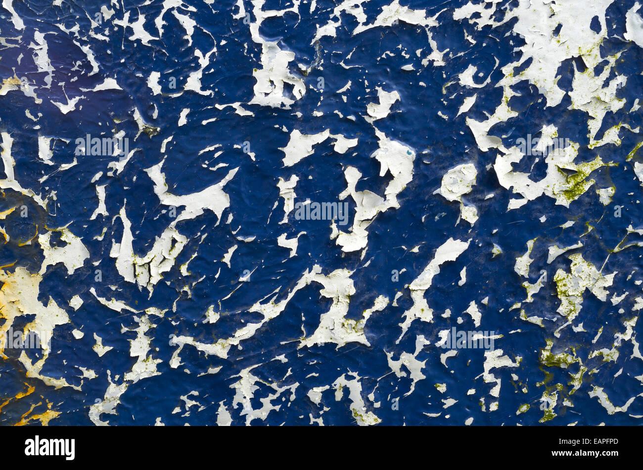 Blaue und weiße abstrakte verwitterte Farbe auf einem Bootsrumpf hautnah. Stockfoto