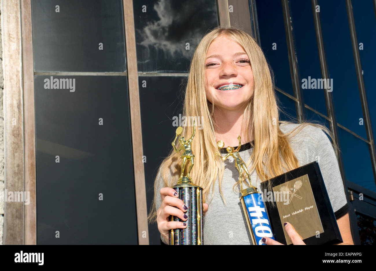 Ein glückliches Mädchen im Teenageralter Tennisspieler zeigen ihre Trophäen. Stockfoto