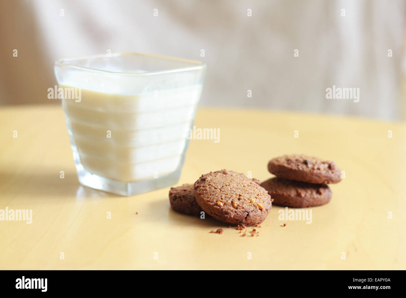 Chocolate Chip Cookies und ein Glas Milch auf einem Holztisch Stockfoto