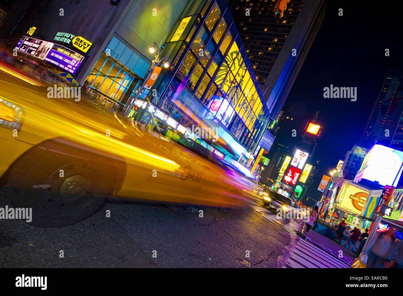 Leuchtreklamen und ein Taxi mit Motion blur in Times Square, Manhattan, New York City, New York, Vereinigte Staaten von Amerika Stockfoto