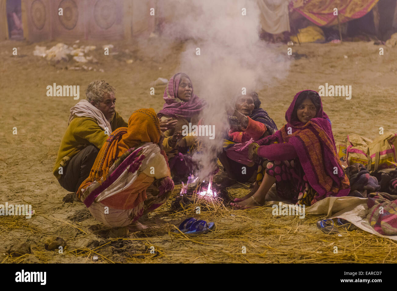 Menschen sammeln auf Kumbha Mela, sitzen um ein Lagerfeuer, Allahabad, Uttar Pradesh, Indien Stockfoto