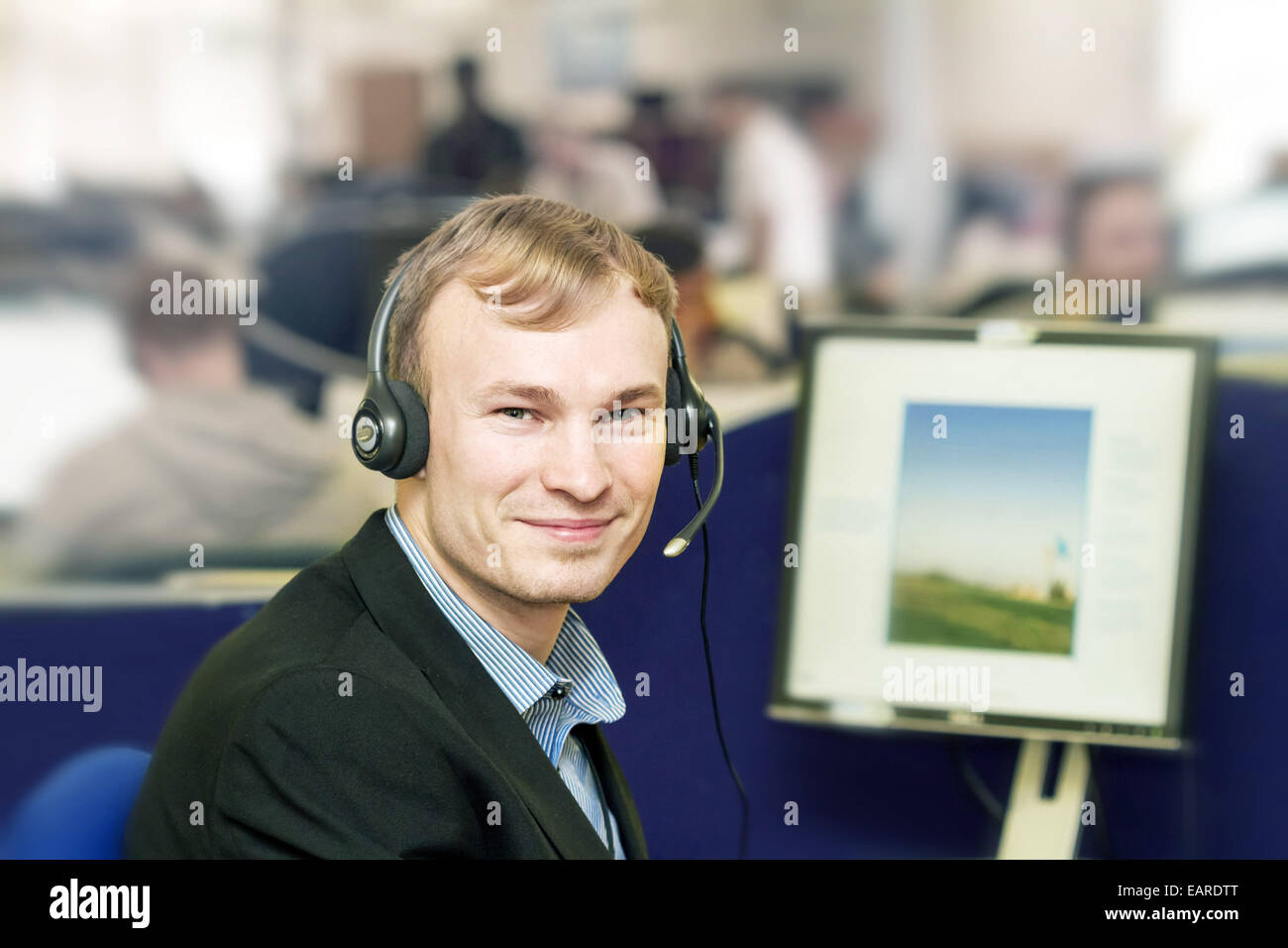 Call-Center-Mitarbeiter - blonder Jüngling trägt ein Audio-Kopfhörer Stockfoto