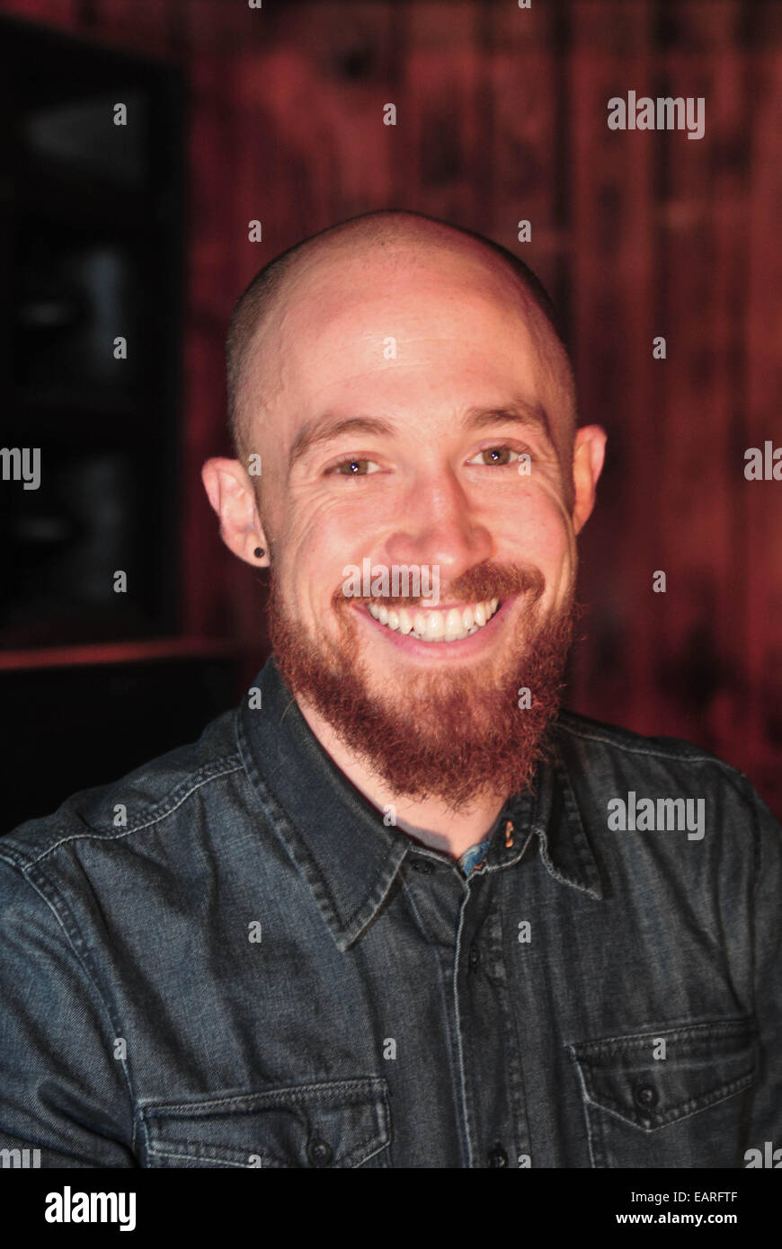 Tom Barber lächelt in die Kamera in Berlin-Friedrichshain, Deutschland, 10. November 2014. Barber ist eines der Organisaters von "Morgen Gloryville", ein Ereignis, das am 3. Dezember 2014 in der neuen Heimat in Friedrichshain stattfindet. Vor dem Frühstück wird es zur elektronischen Musik getanzt werden. Foto: Friedrich Bungert/dpa Stockfoto