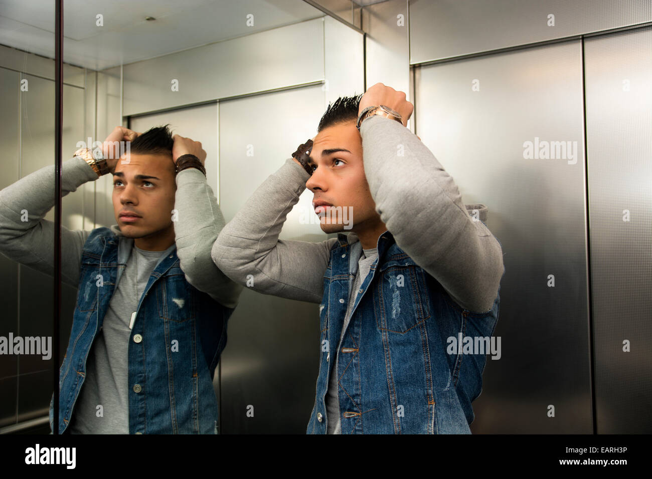 Angst junger Mann verzweifelt in stecken Aufzug mit den Händen auf dem Kopf Stockfoto