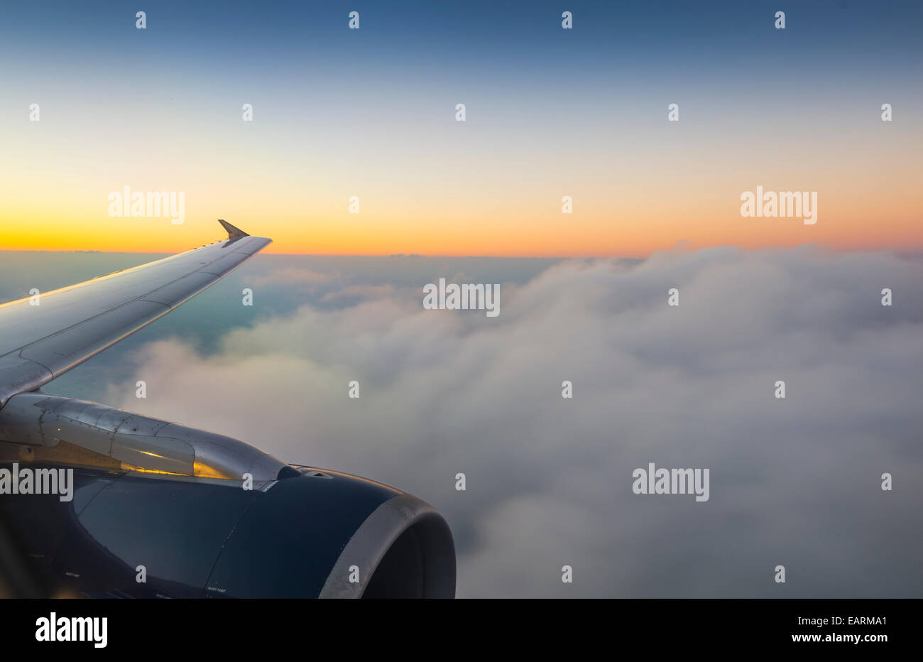 Flugzeugflügel und Wolken mit Sonnenuntergang Stockfoto