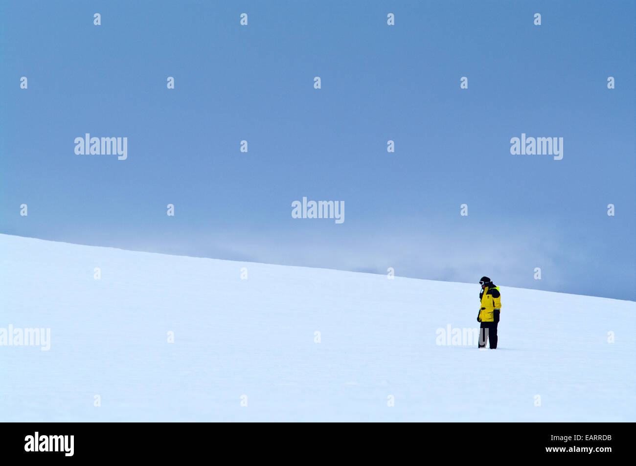 Ein Expeditionsleiter untersucht Abhanges kargen Eis auf eine schroffe Insel. Stockfoto