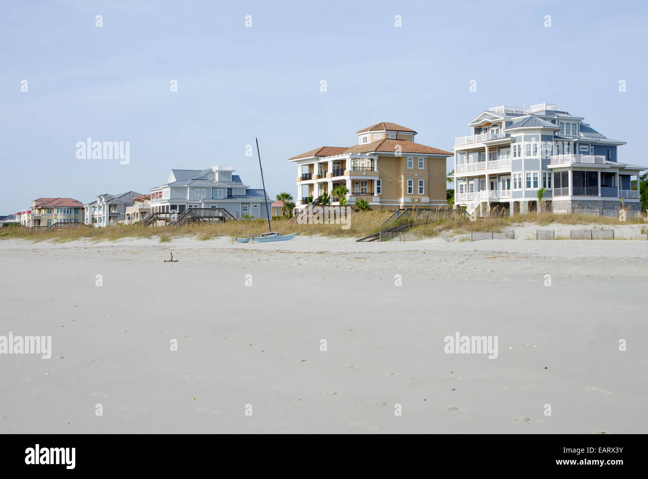 Eine Reihe von direkt am Meer, gehobene, Strandhäuser. Kurz nach Sonnenaufgang mit schönen Licht und Himmel genommen. Stockfoto