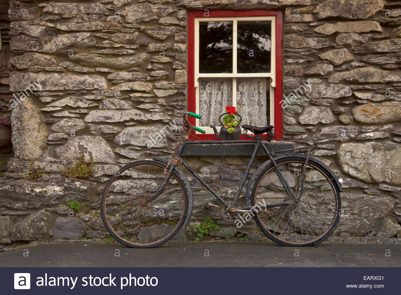 Ein altes Fahrrad liegt an einem alten Steinhaus. Stockfoto