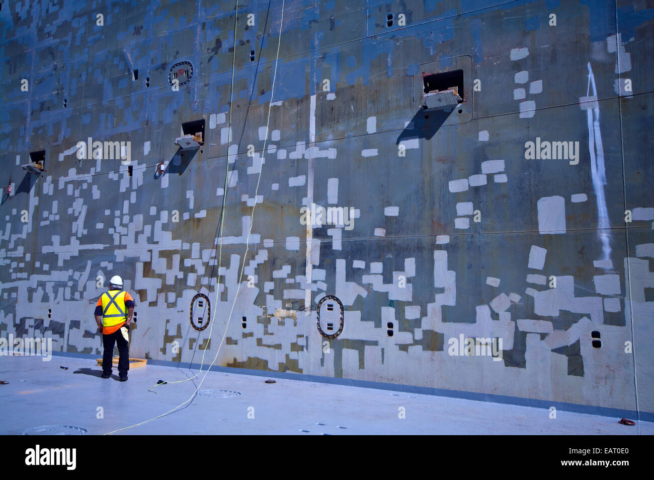 Ein Schiffsbelader inspiziert eine Schiffe Frachtraum für Stahlkorrosion. Stockfoto