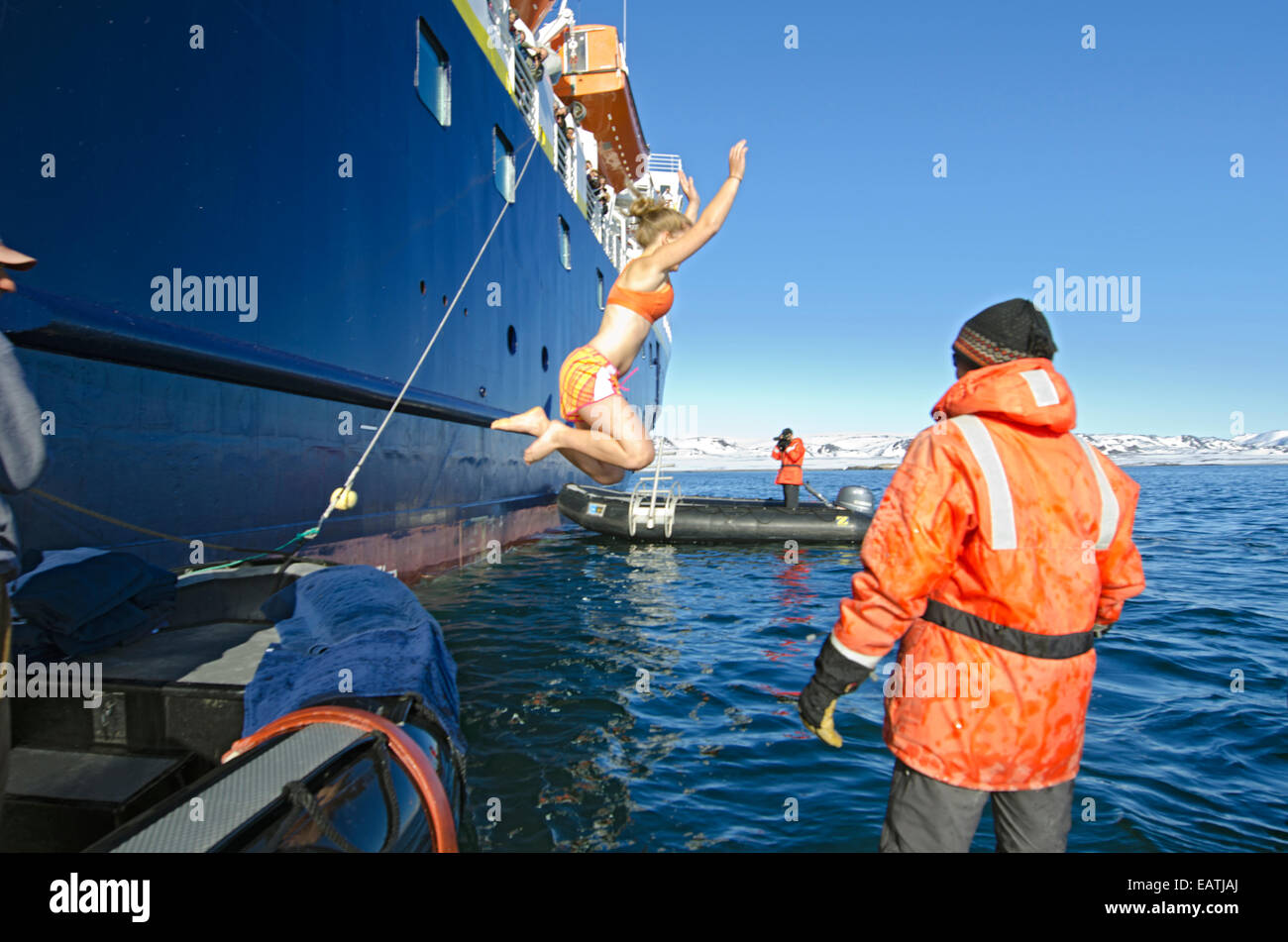 Ein Tourist unter einer polaren Sprung in den eisigen Gewässern der Mosselbukta. Stockfoto