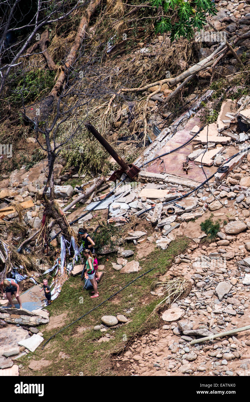 Touristen suchen Schutt und Geröll aus einer Safari-Lodge nach einer Überschwemmung. Stockfoto
