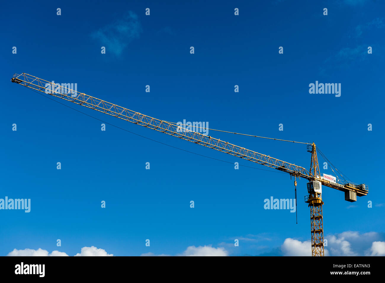 Ein Kran Bauboom erstreckt sich in einem klaren blauen Himmel. Stockfoto