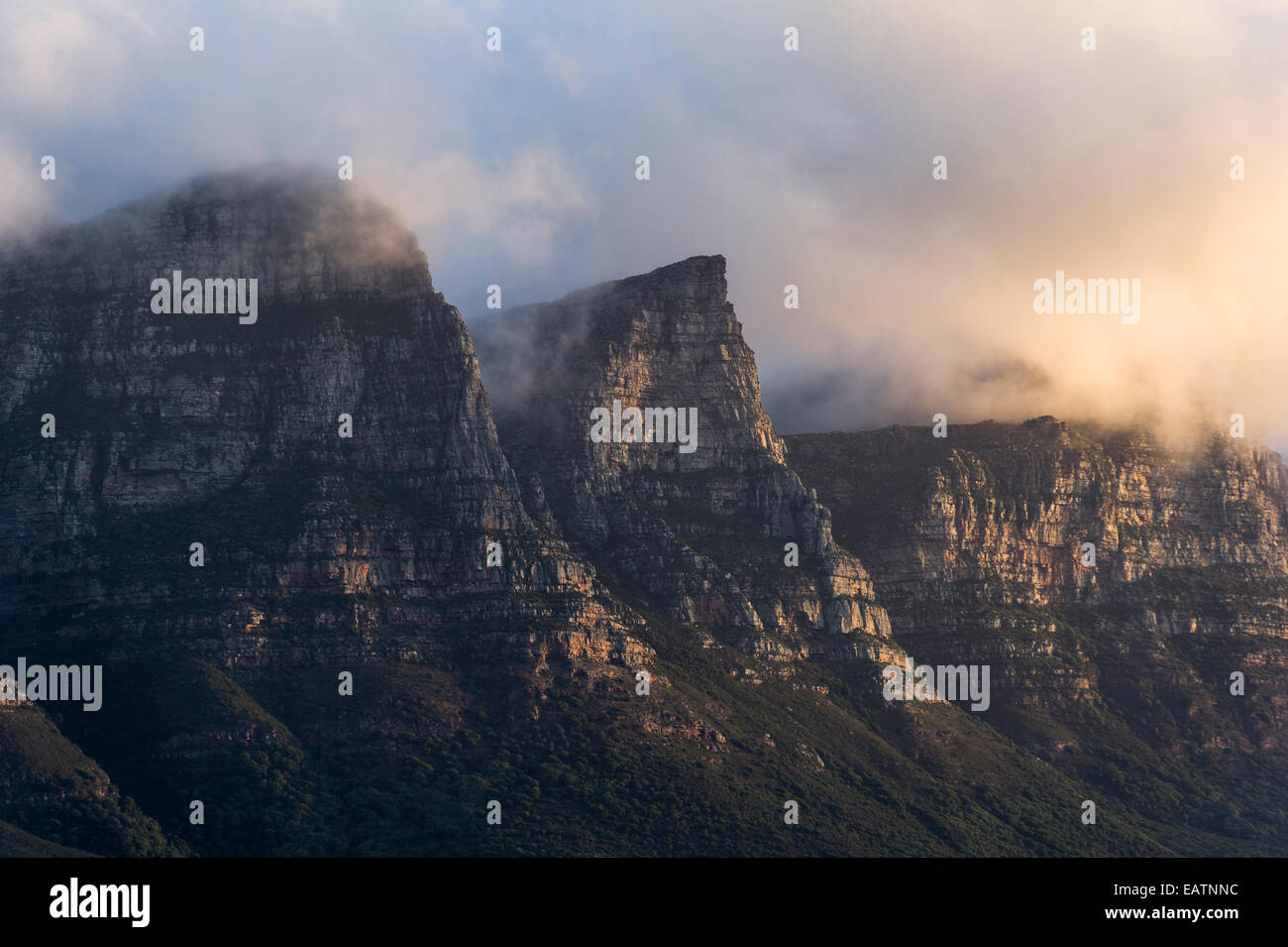 Bedrohliche Sonnenuntergang Gewitterwolken verbrauchen eine zerklüftete Küstengebirge. Stockfoto