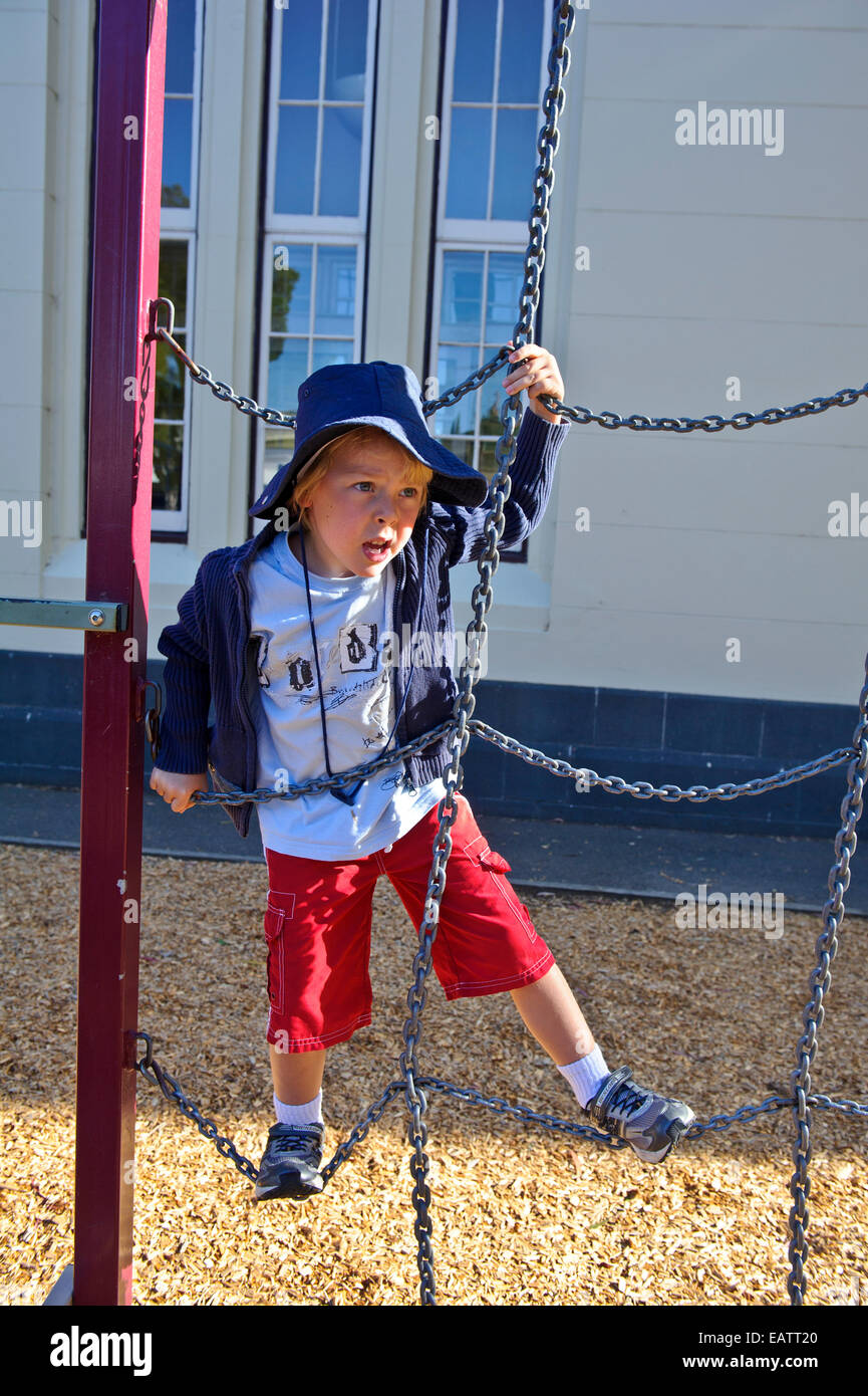 Ein Junge beschäftigt sich mit den Spielgeräten an seinem ersten Tag der Schule. Stockfoto
