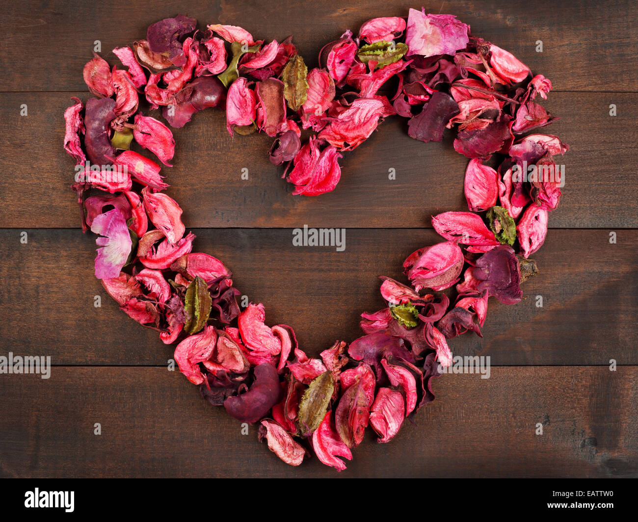 Blütenblätter bilden eine Herzform Holz Hintergrund Stockfoto