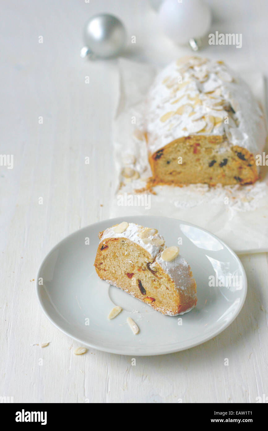 Süßes Brot über weiße Platte Scheibe. Brotlaib und Weihnachtsschmuck im Hintergrund. Stockfoto