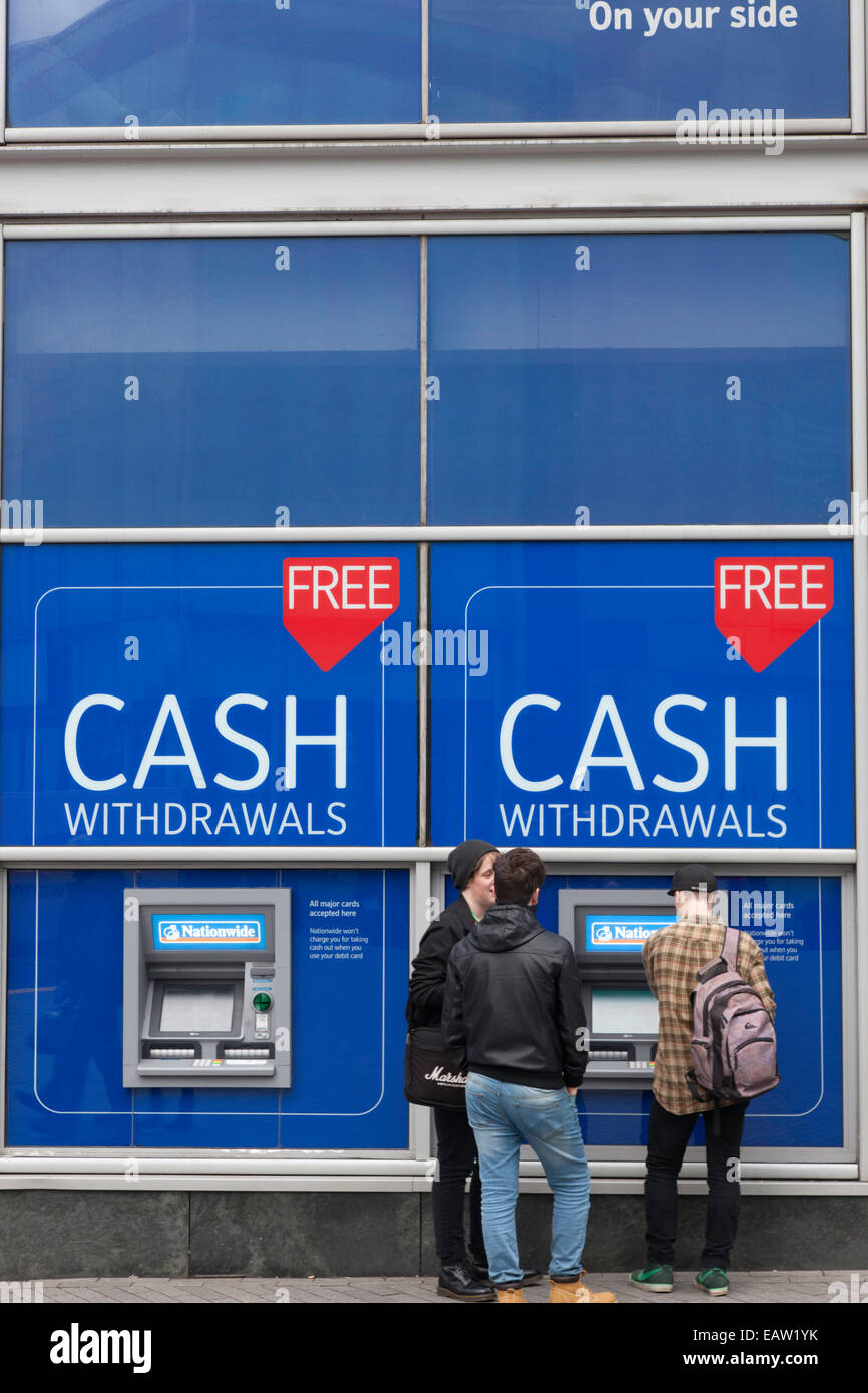 Junge Männer am Geldautomat, England, UK Stockfoto