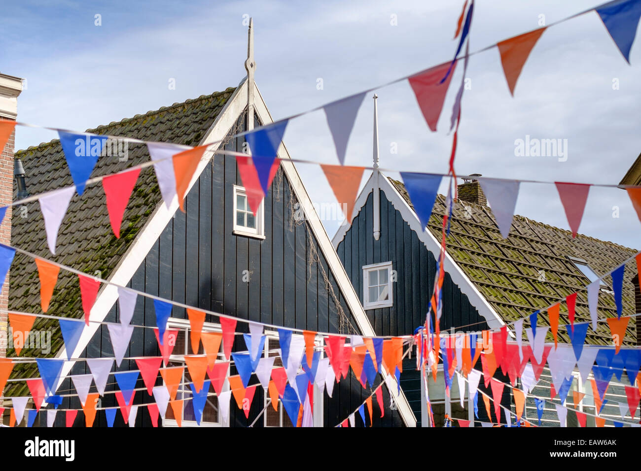 Traditionelle Holzhäuser, geschmückt mit Fahnen der holländischen Nationalfarben für Koningsdag oder Königstag, Marken, Nordholland, Niederlande Stockfoto