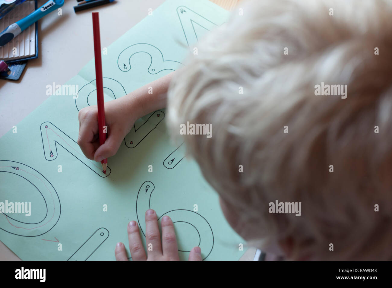 eine 7-jährige Schulkind tut Schreibübungen als Hausaufgabe für die Grundschule. Stockfoto