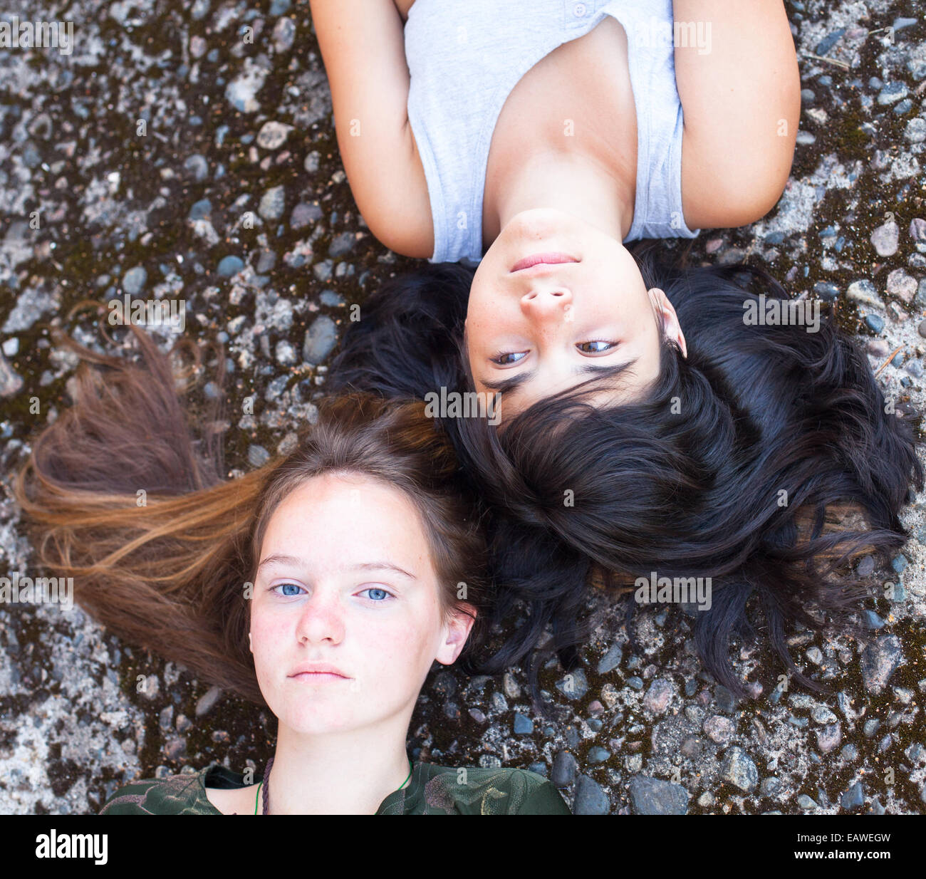 Zwei Teenager Freundinnen liegen auf einem Granit-Hintergrund, Top anzeigen close-up. Stockfoto