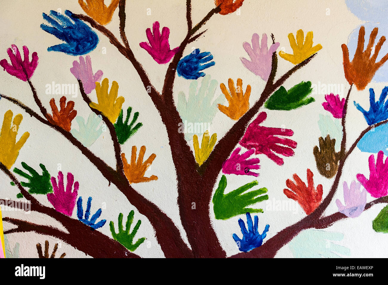 Handabdrücke von Schulkindern bilden bunte Blätter auf einem Wandbild. Stockfoto
