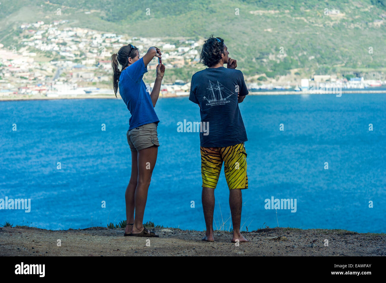 Touristen fotografieren eine malerische Bucht von einer Klippe über dem Meer. Stockfoto