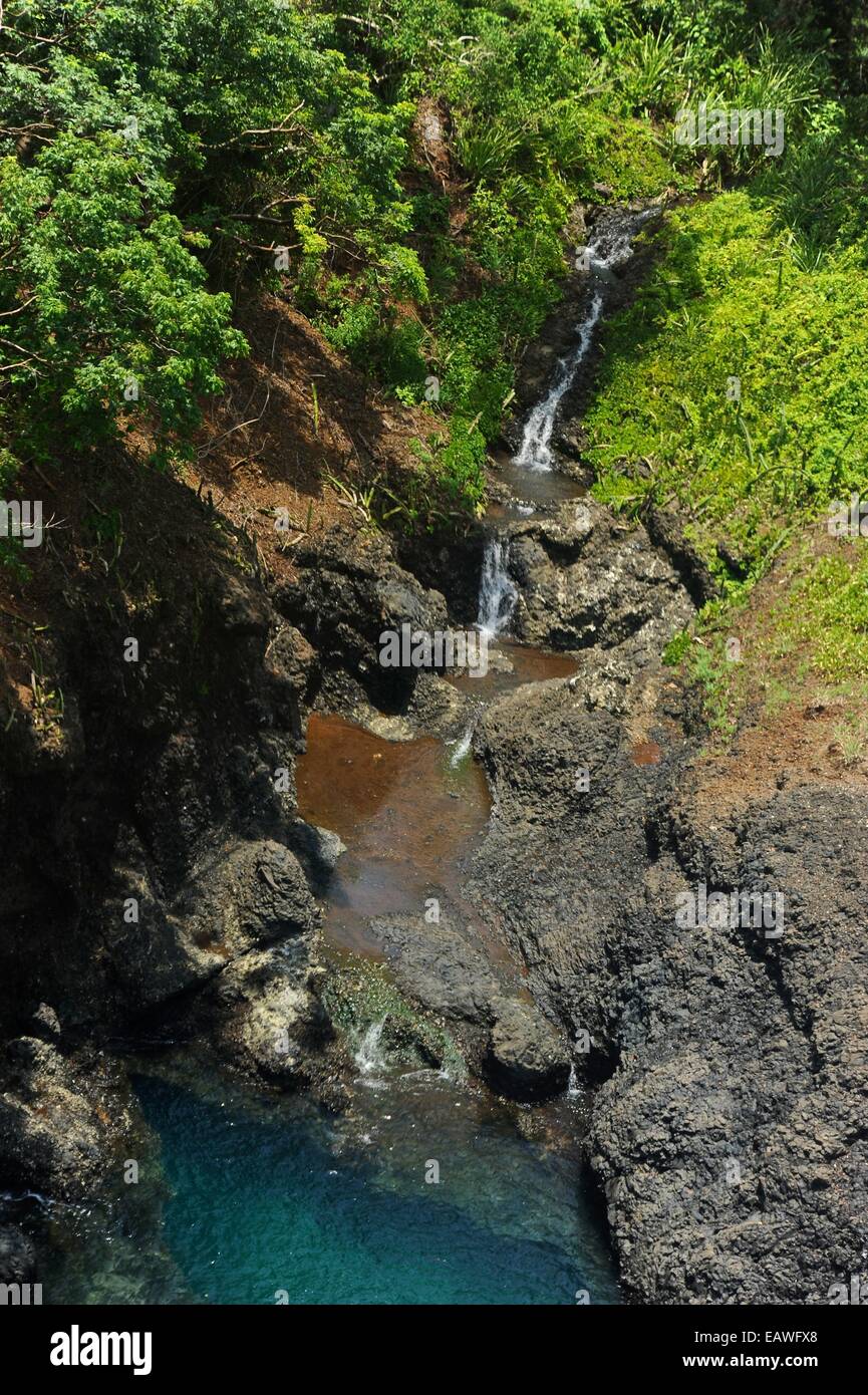 Ein schmale Wasserfall mündet in das klare Wasser der Pearl Islands. Stockfoto