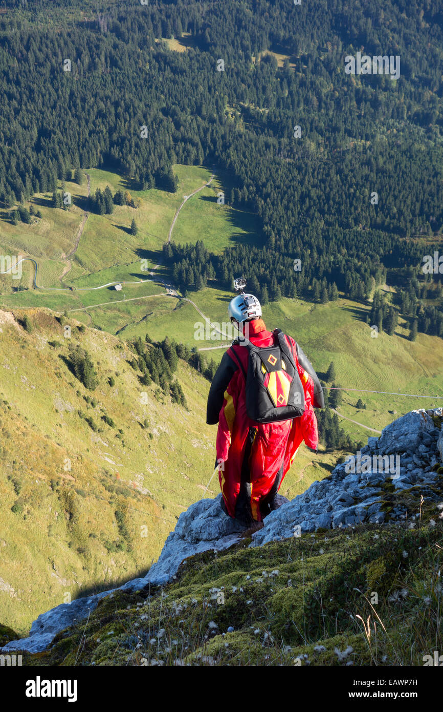 Wingsuit Base-Jumper bereitet sich in das tiefe Tal von einer Klippe springen und er sieht sehr nervös. Stockfoto