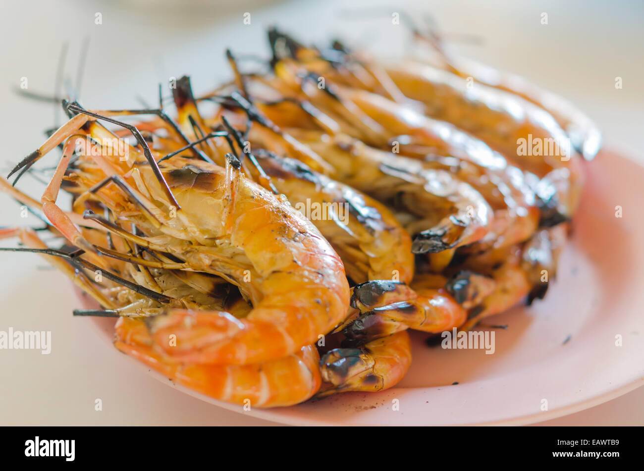 gegrillte Garnelen auf einem Teller am Tisch hautnah Stockfoto