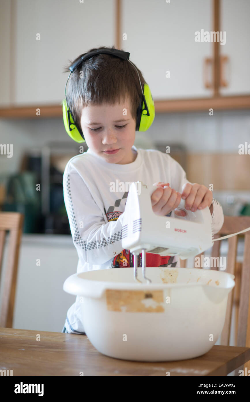 Jungen tragen gelbe Kopfhörer benutzt einen elektrischen mixer Stockfoto