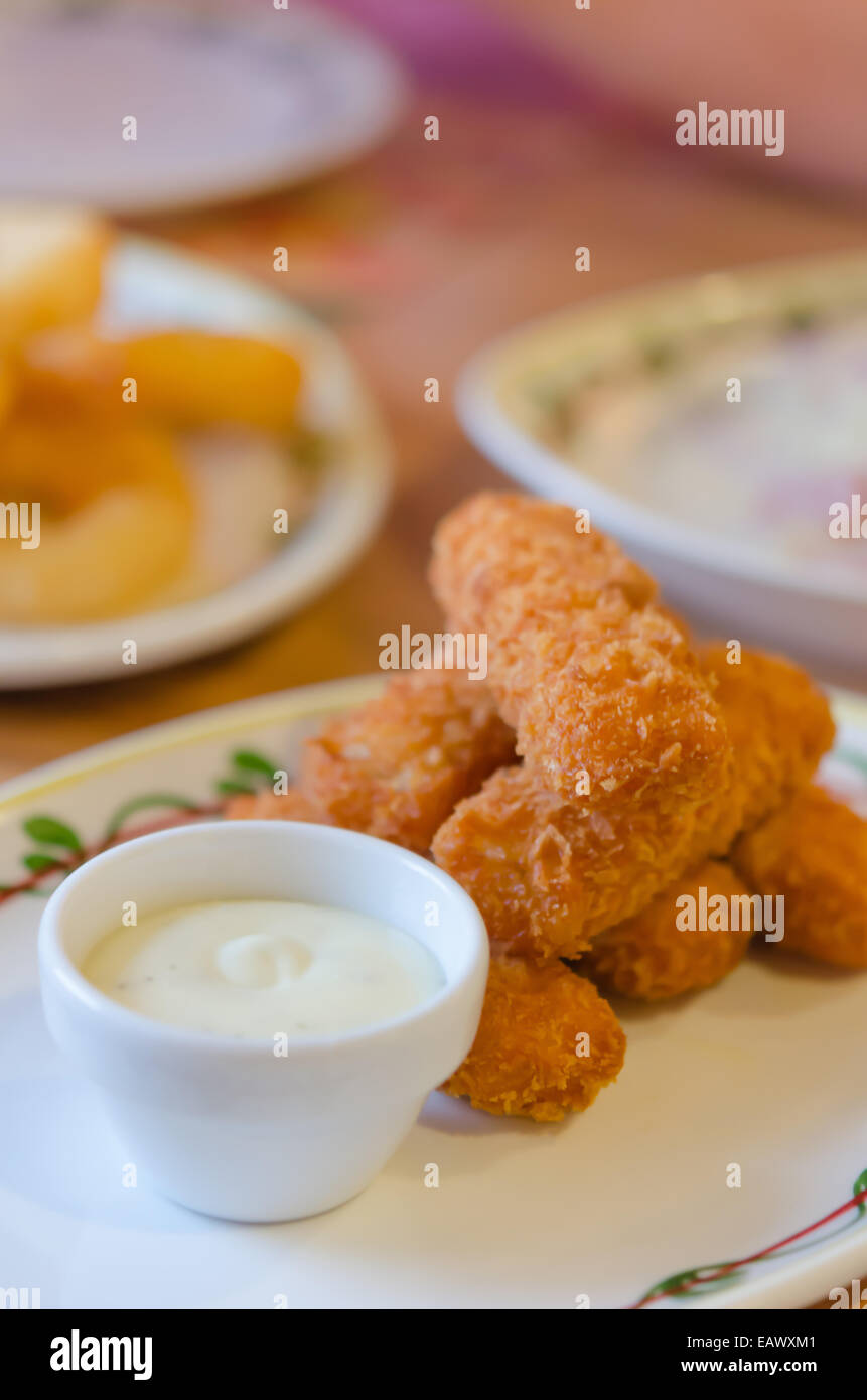 frische Fischstäbchen und weisse Sauce auf Teller Stockfoto