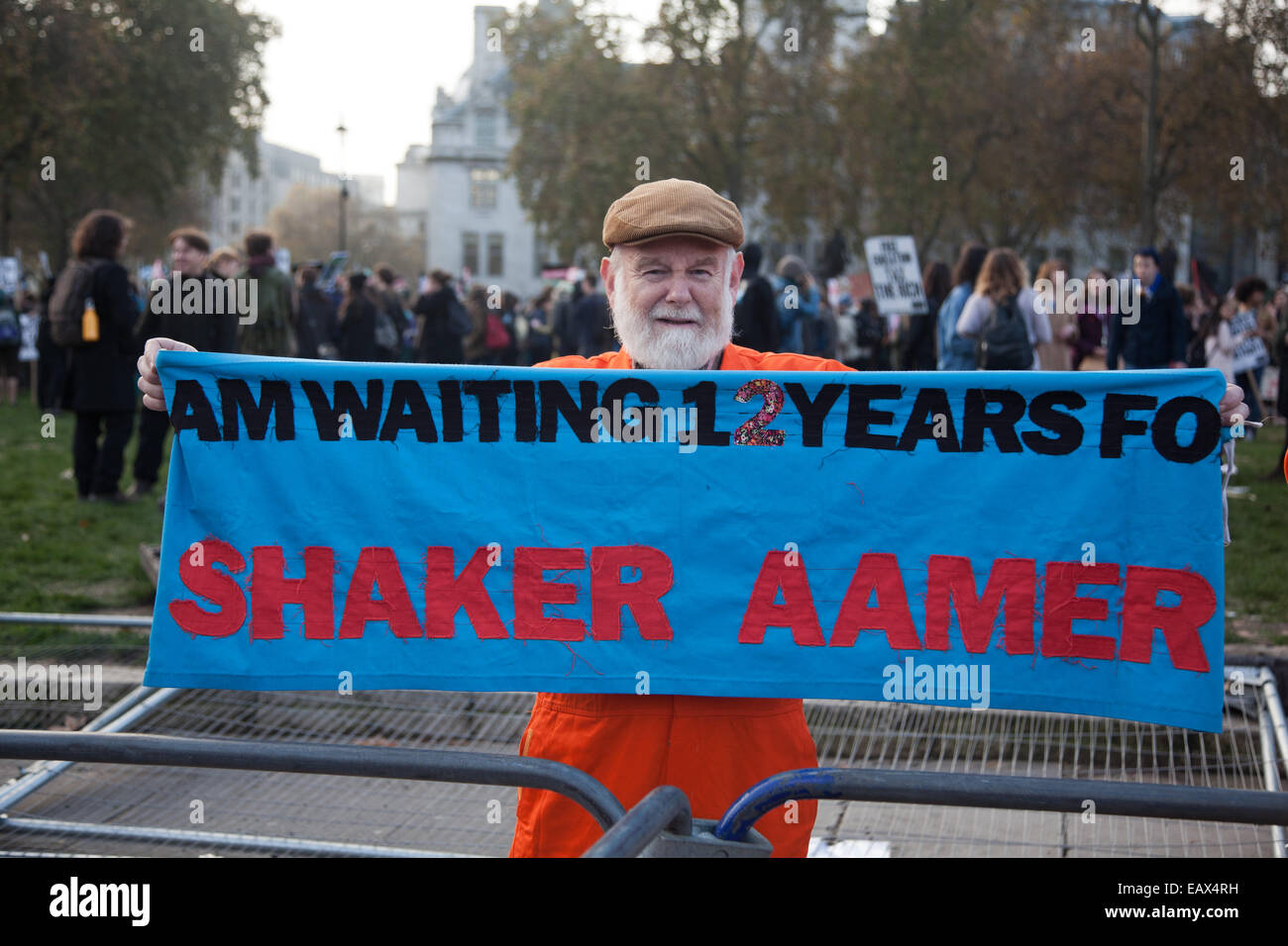 Ein Mann in orange Sprunganzug hält ein transparent in Parliament Square besagt, dass er wartet Shaker Ameer, 12 Jahre auf. Stockfoto