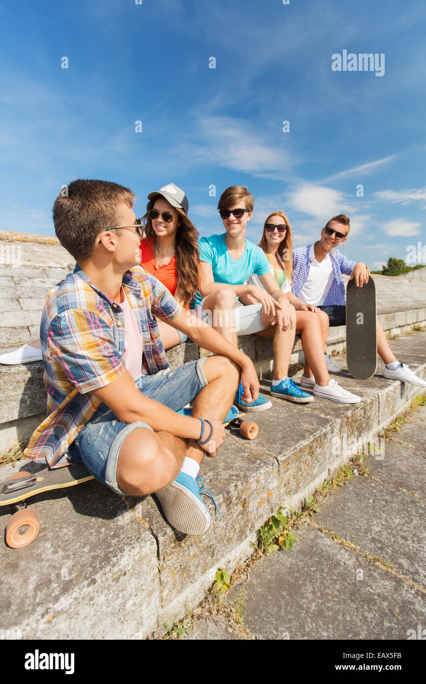 Gruppe von lächelnden Freunde sitzen auf Stadtstraße Stockfoto