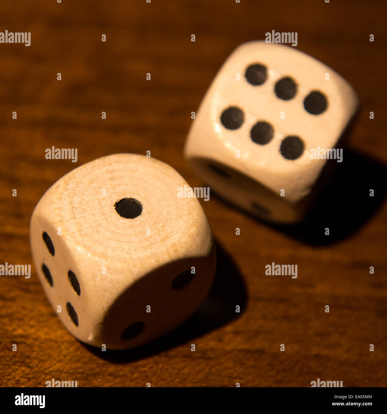 Würfel mit Nummer 1 und 4 auf Holztisch Stockfoto