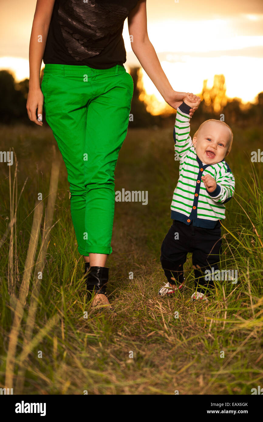 Entzückende Baby herum mit Mutter Stockfoto