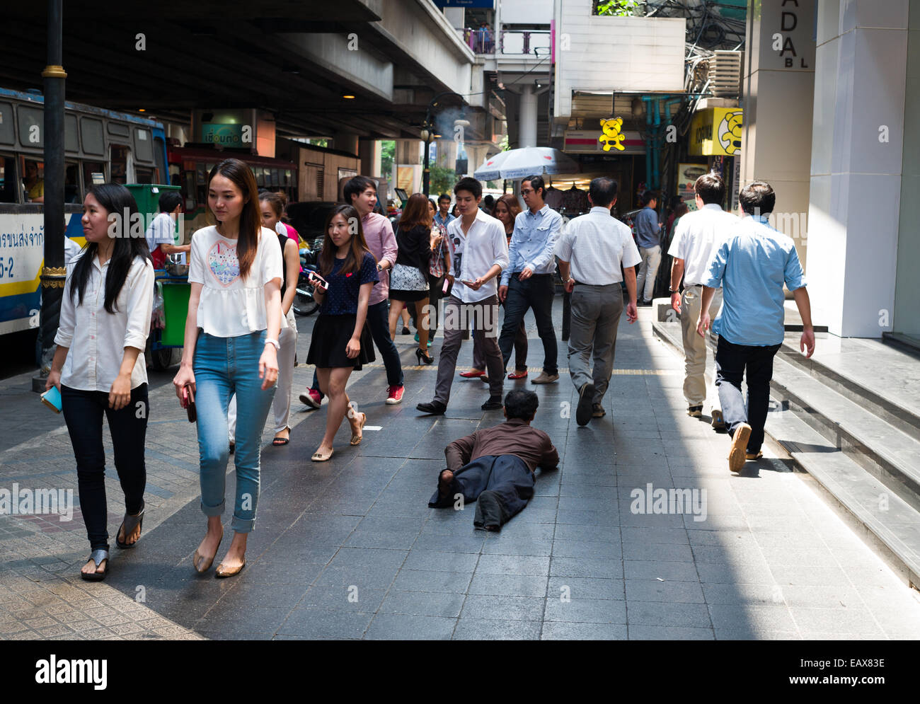 Behinderten Bettler auf der Silom Road, Bangkok, Thailand als Mittelschicht Fuß durch. Stockfoto