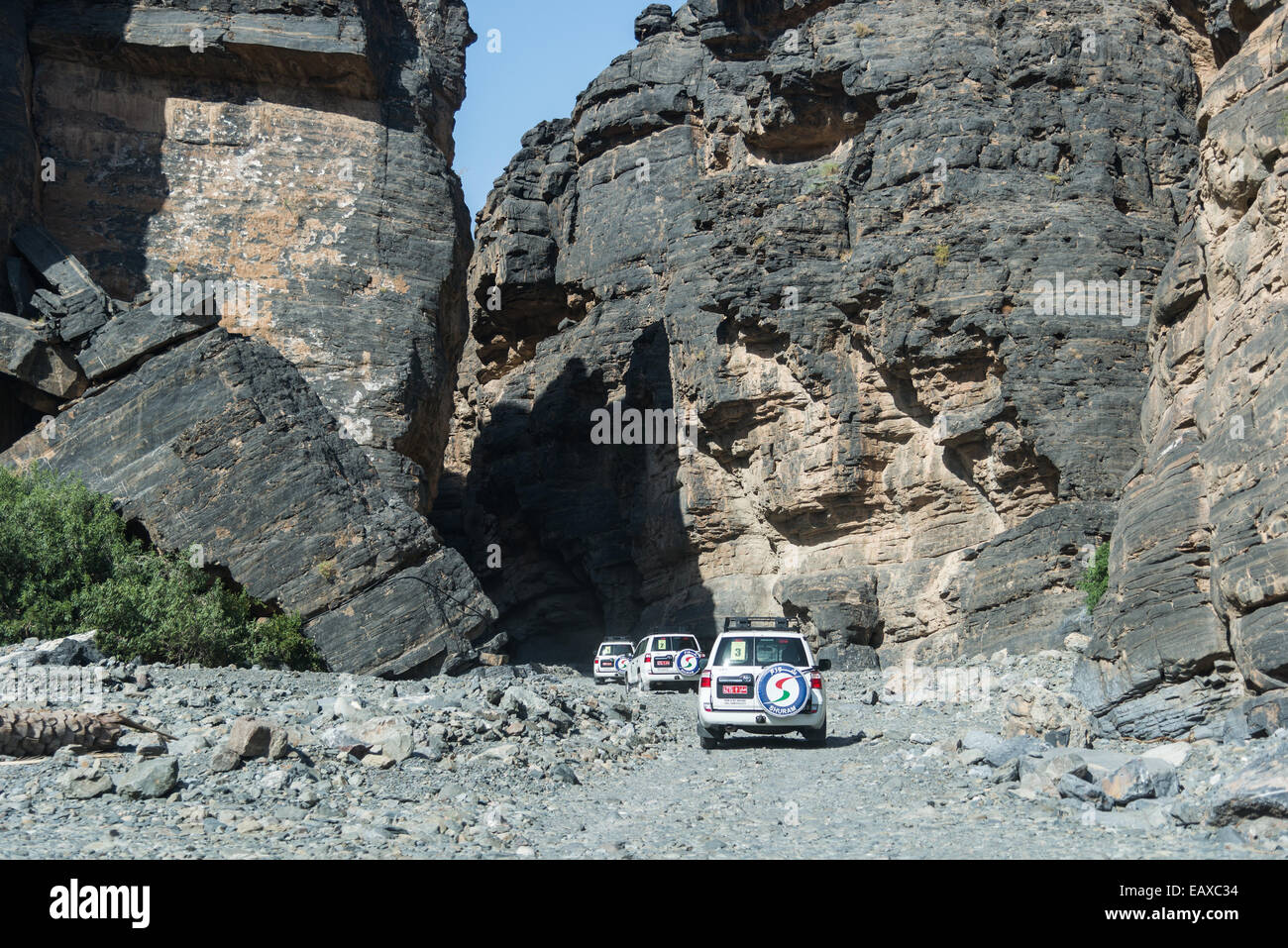 Ein Konvoi von SUVs, die in einer engen Schlucht fahren. Oman. Stockfoto