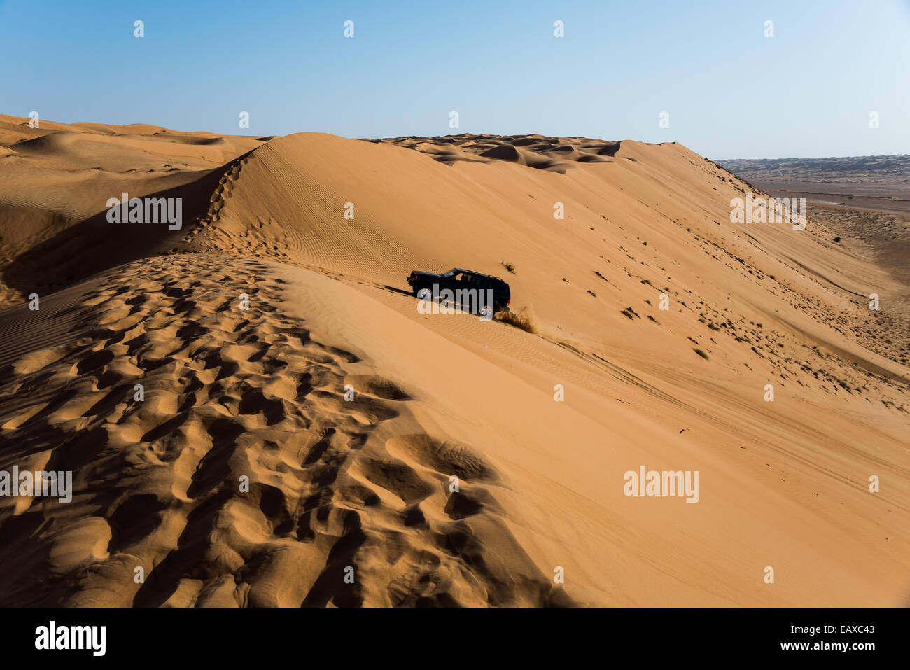 Ein Allrad-Antrieb-Jeep fahren über Sanddünen in der Wüste von Oman. Stockfoto